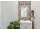 Stylish powder room with patterned wallpaper, a decorative mirror, and a gray vanity at 41624 N Anthem Ridge Dr, Anthem, AZ 85086