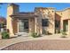 Home exterior features a covered patio with stone pillars and manicured desert landscaping at 4241 N Pebble Creek Pkwy # 54, Goodyear, AZ 85395