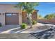 Exterior view of a well-maintained home with a stone facade, an attached garage, and neat landscaping at 4241 N Pebble Creek Pkwy # 54, Goodyear, AZ 85395