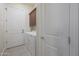 Bright laundry room features white washer and dryer, brown cabinets, tile floor and doors at 4241 N Pebble Creek Pkwy # 54, Goodyear, AZ 85395