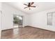 Large bedroom featuring wood floors, ceiling fan, and a sliding glass door at 4245 E Jason Dr, Phoenix, AZ 85050