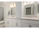 Bright bathroom featuring double sinks, white cabinets, vanity lights, and modern framed mirrors at 4536 E Beck Ln, Phoenix, AZ 85032