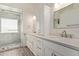 Updated bathroom features double sinks, white cabinets, quartz countertops, and access to the frameless shower at 4536 E Beck Ln, Phoenix, AZ 85032