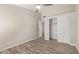 Bedroom with wood-look floors, closet with sliding doors, and an adjacent bedroom behind a white door at 4536 E Beck Ln, Phoenix, AZ 85032