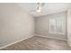 Bedroom featuring wood-look floors, neutral walls, a ceiling fan, and bright window with shutters at 4536 E Beck Ln, Phoenix, AZ 85032