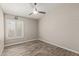 Bedroom featuring wood-look floors, neutral walls, a ceiling fan, and a window with bright shutters at 4536 E Beck Ln, Phoenix, AZ 85032