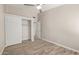 Bedroom with wood-look floors, closet with sliding doors, and an adjacent bedroom behind a white door at 4536 E Beck Ln, Phoenix, AZ 85032
