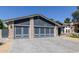 Exterior shot highlighting the spacious three-car garage with brick accents and modern gray doors at 4536 E Beck Ln, Phoenix, AZ 85032