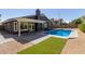 Backyard swimming pool with covered patio, artificial turf, and a view of the home's rear facade at 4536 E Beck Ln, Phoenix, AZ 85032