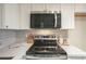 Modern kitchen featuring stainless steel appliances, white cabinets, and stylish backsplash at 4901 S Calle Los Cerros Dr # 236, Tempe, AZ 85282