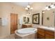 Bright bathroom featuring a soaking tub, tiled floors, double sinks, and wooden accents at 5370 S Desert Dawn Dr # 50, Gold Canyon, AZ 85118