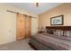 Cozy bedroom with barn door access, a patterned bedspread, and warm, inviting decor at 5370 S Desert Dawn Dr # 50, Gold Canyon, AZ 85118