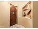 Inviting entryway featuring a wooden arched door and decorative niche, enhancing the home's character at 5370 S Desert Dawn Dr # 50, Gold Canyon, AZ 85118
