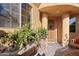 Charming patio with plants, bench seating and an arched wooden front door at 5370 S Desert Dawn Dr # 50, Gold Canyon, AZ 85118