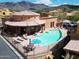 Community pool and spa area with lounge chairs and mountain views at 5370 S Desert Dawn Dr # 50, Gold Canyon, AZ 85118
