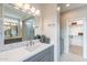 Bathroom featuring marble countertops, a modern sink, vanity mirror and a walk-in closet at 623 E Peach Tree St, Queen Creek, AZ 85140