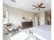 A cozy bedroom features a decorative chair, a dresser, and a ceiling fan, creating a relaxing and inviting space at 623 E Peach Tree St, Queen Creek, AZ 85140