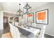 Elegant dining room with stylish lighting, gray walls, and view to kitchen at 623 E Peach Tree St, Queen Creek, AZ 85140