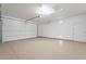 Clean, spacious garage with epoxy flooring, a large garage door, and a side entry door at 623 E Peach Tree St, Queen Creek, AZ 85140
