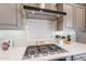 Close-up of a modern kitchen with stainless steel appliances, stylish backsplash, and gas cooktop at 623 E Peach Tree St, Queen Creek, AZ 85140