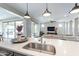 Modern kitchen with a large island, stainless steel sink, and views of the living room and outdoor patio at 623 E Peach Tree St, Queen Creek, AZ 85140