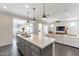 Open-concept kitchen with a large island, pendant lighting, and seamless flow into the dining and living areas at 623 E Peach Tree St, Queen Creek, AZ 85140