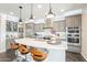 Open kitchen with stainless steel appliances, pendant lights, and bar stool seating at 623 E Peach Tree St, Queen Creek, AZ 85140