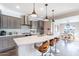 Bright kitchen features stainless steel appliances, a center island with seating and modern pendant lighting at 623 E Peach Tree St, Queen Creek, AZ 85140