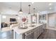 Open-concept kitchen with stainless steel appliances, center island with seating, and sightlines to the living room at 623 E Peach Tree St, Queen Creek, AZ 85140