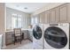 Spacious laundry room featuring built-in cabinets, counter space, and modern washer and dryer at 623 E Peach Tree St, Queen Creek, AZ 85140
