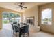 Covered patio featuring a dining table, outdoor fireplace, ceiling fan and scenic golf course views at 623 E Peach Tree St, Queen Creek, AZ 85140