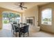 Covered patio featuring an outdoor fireplace, ceiling fan, and a dining table with seating for six at 623 E Peach Tree St, Queen Creek, AZ 85140