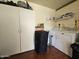 A well-lit laundry room featuring a washing machine, dryer, and ample storage cabinets at 650 N Hawes Rd # 4406, Mesa, AZ 85207