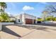 The property's two-car garage has wooden doors and a large driveway and an outdoor basketball court at 6700 E Caron Dr, Paradise Valley, AZ 85253