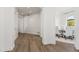 Bright hallway with wood floors leading to the dining room with white walls and archways at 6700 E Caron Dr, Paradise Valley, AZ 85253
