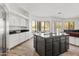Open concept kitchen features an island, stainless steel appliances, white cabinets, and wood flooring at 6700 E Caron Dr, Paradise Valley, AZ 85253