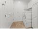 Well-lit laundry room with built-in storage, travertine tile flooring, and modern washer and dryer at 6700 E Caron Dr, Paradise Valley, AZ 85253