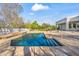Beautiful in-ground pool featuring stone coping, surrounded by lush trees and an elegant home exterior at 6700 E Caron Dr, Paradise Valley, AZ 85253