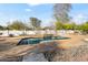 Inviting in-ground pool with stone coping, surrounded by desert landscaping and mature trees for privacy at 6700 E Caron Dr, Paradise Valley, AZ 85253