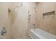 Bathroom shower featuring tile surround, grab bars, rainfall shower head, and built in niche at 6700 E Caron Dr, Paradise Valley, AZ 85253