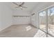 Bright bedroom with a ceiling fan, neutral carpet, and a sliding glass door to the backyard at 701 Dylan Ct, Wickenburg, AZ 85390