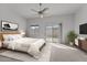 Sun-filled main bedroom with a king bed, neutral tones, and sliding doors leading to a private patio at 701 Dylan Ct, Wickenburg, AZ 85390
