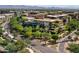 Aerial view of a modern complex with lush landscaping, mature trees, and mountains in the background at 7151 E Rancho Vista Dr # 1003, Scottsdale, AZ 85251
