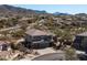 A high angle view of the home that shows the desert landscaping, roof, and attached three car garage at 7424 E Sandia Cir, Mesa, AZ 85207