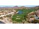 A high angle view of the golf course, green space, and property amongst the mountains and neighborhood at 7424 E Sandia Cir, Mesa, AZ 85207