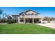 Lush backyard featuring green lawn, covered patio, desert landscaping and mature trees at 7424 E Sandia Cir, Mesa, AZ 85207