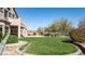 Lush backyard with a well-manicured green lawn, desert landscaping, and mature trees at 7424 E Sandia Cir, Mesa, AZ 85207