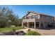 Spacious backyard with a green lawn, patio area, desert landscaping and mature trees at 7424 E Sandia Cir, Mesa, AZ 85207