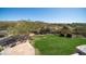 The backyard offers an expansive lush lawn, mature trees, and beautiful landscaping, perfect for outdoor enjoyment at 7424 E Sandia Cir, Mesa, AZ 85207