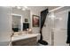 Bathroom with updated vanity, framed mirror, and glass enclosed shower in neutral tones with black accents at 7424 E Sandia Cir, Mesa, AZ 85207